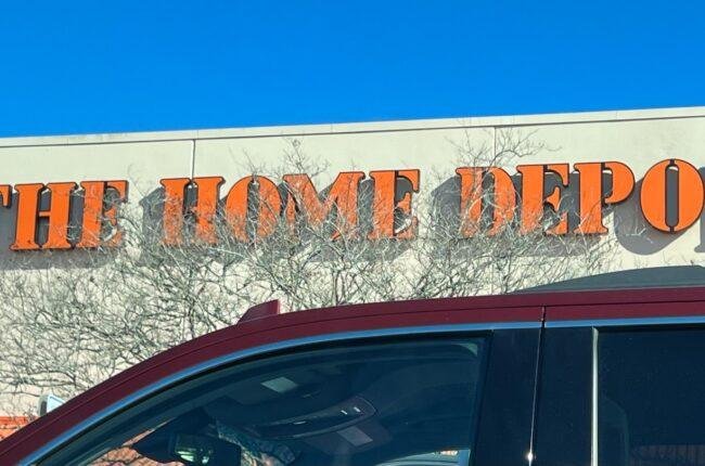 a red car parked in front of a home depot