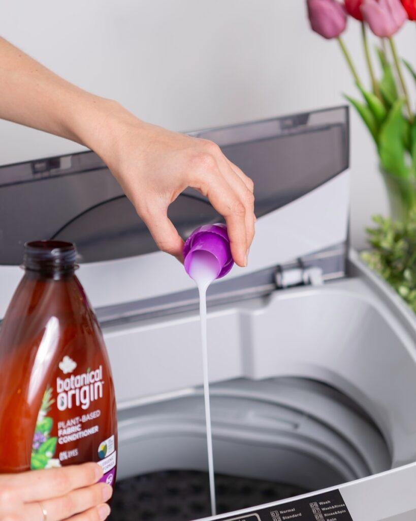 person holding laundry detergent for washing machine